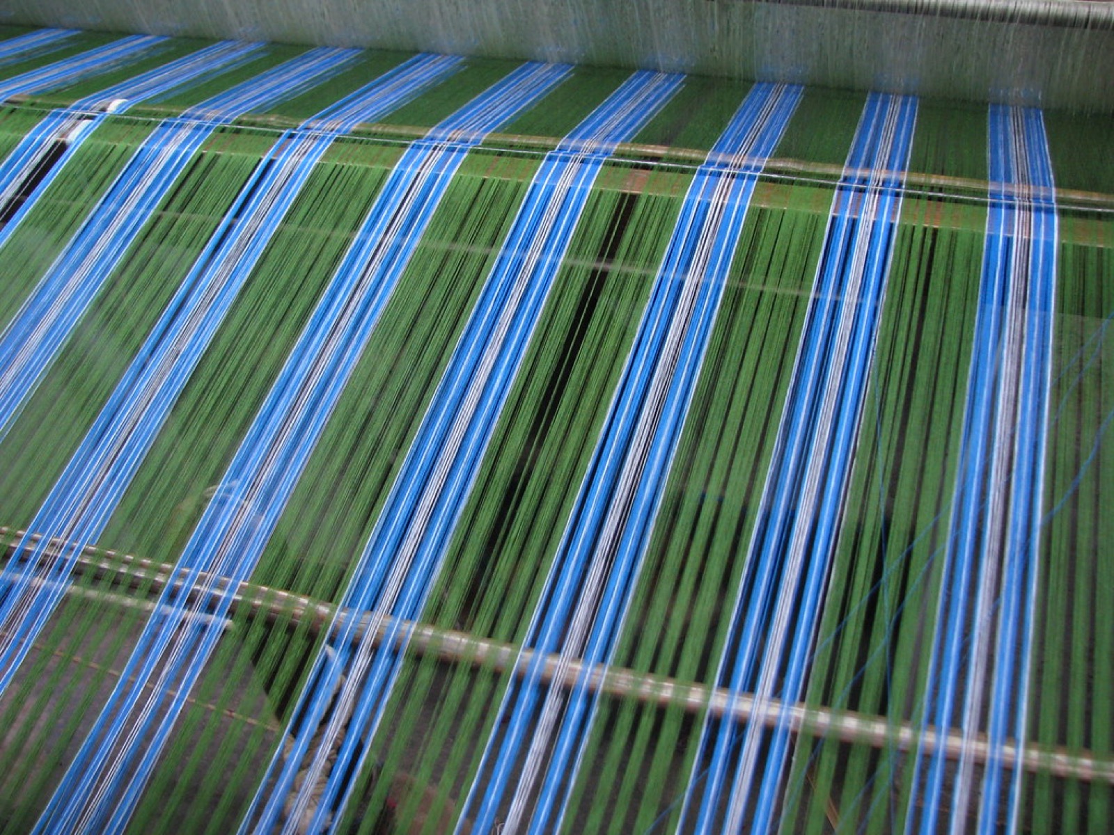 A person weaving cloth on a handloom
