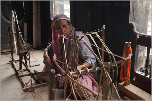 A person spinning thread by hand