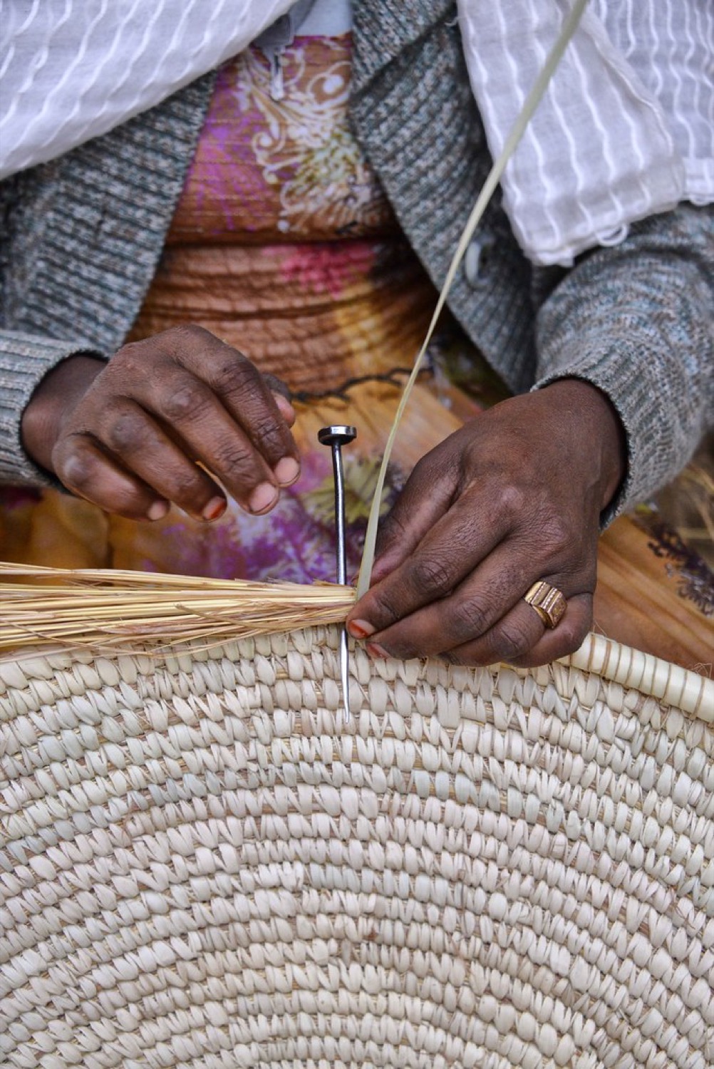 Hands weaving a basket